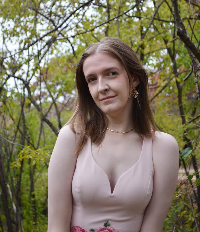 young woman wearing a pink dress in an outdoor setting