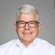 headshot photo of man in white shirt and glasses