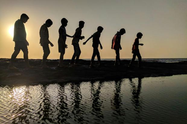 Silhouette of children against a sunset.