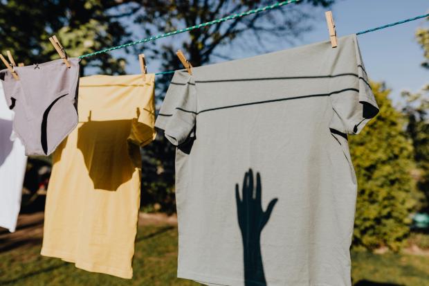 Clothing on a line with a shadow of a hand
