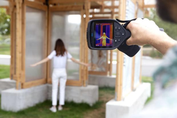 A heat scan being taken on a human under a cooling cover structure