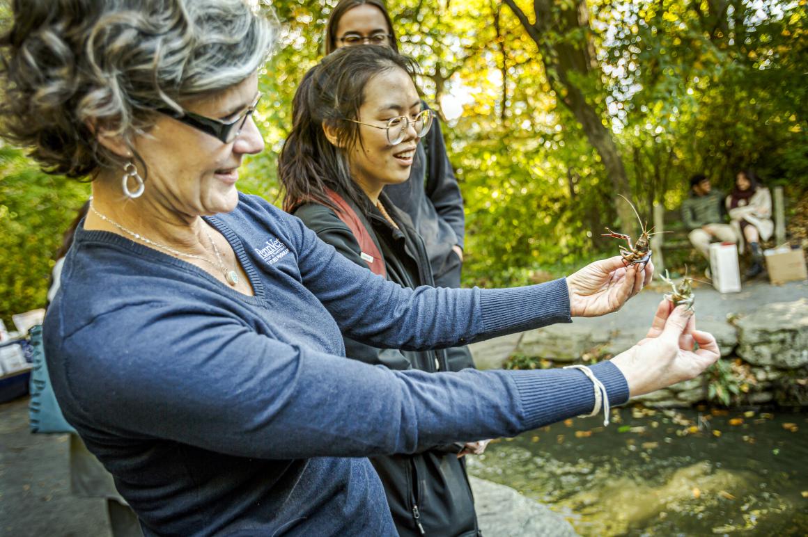 Julie Ellis holding arthropods on her hands at the biopond
