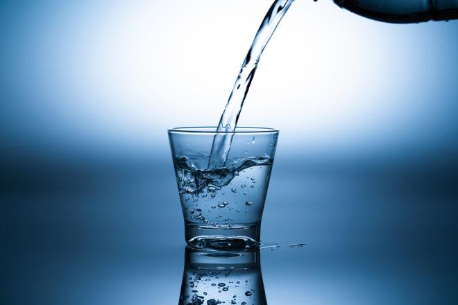 A glass of water being poured.