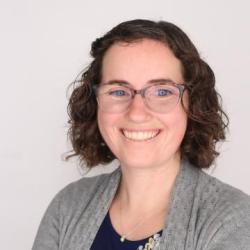 woman with dark hair and glasses